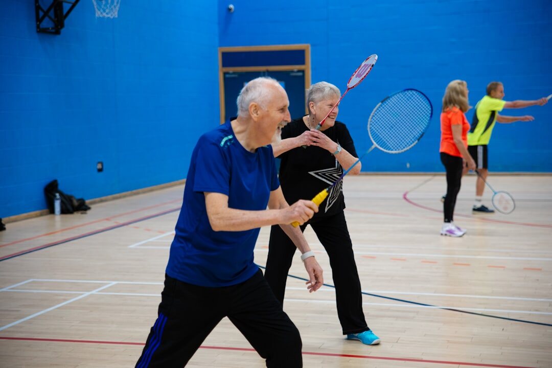 Seniors doing a gentle group exercise session in a hall